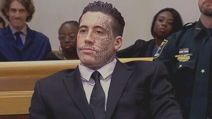 Wade Wilson sitting in court wearing a suit