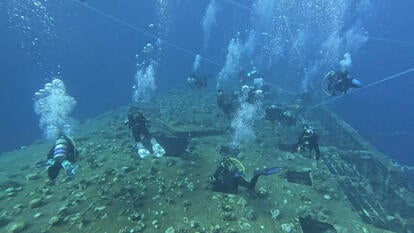Divers exploring underwater wreckage