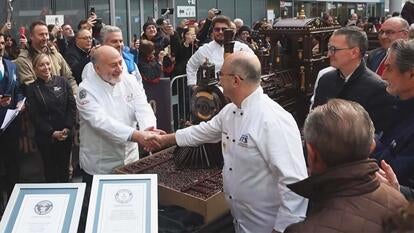 Chefs shake hands in front of longes chocolate train