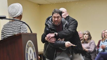 Security restrains Anthony Kazmierczak at Rep. Ilhan Omar's town hall 