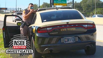 Florida State Trooper pointing a speed gun at cars passing on the highway