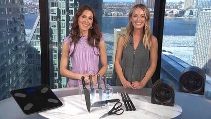 Two women standing behind a table displaying a Scale, Knife Bundle, Heaters