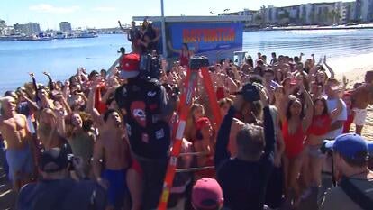 Large crowd of people cheering for a photo taken by a man on a ladder 