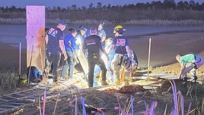 Rescuers helping dig man out of mud