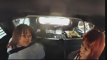Two teens laughing in a police car after arrest