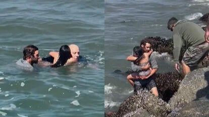 Two men and a child in ocean, man carries child out of ocean
