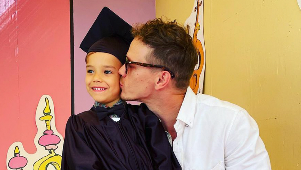 5-year-old Josey pictured in cap and gown with his father Ryan Dorsey kissing him on the cheek.