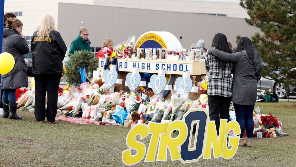 People gather at the memorial for the dead and wounded outside of Oxford High School in Oxford, Michigan on December 3, 2021. 