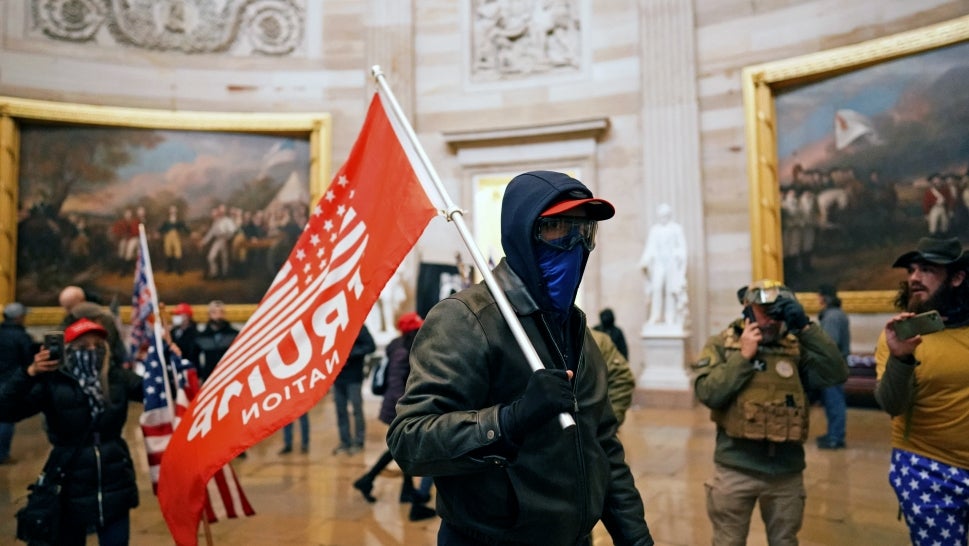 A rioter waves a "Trump Nation" flag inside the Capitol on Jan. 6, 2021.
