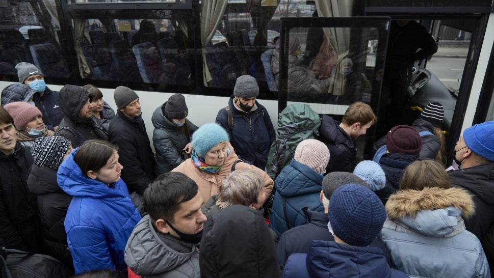 People board a bus as they attempt to evacuate the city on February 24, 2022 in Kyiv, Ukraine. Overnight, Russia began a large-scale attack on Ukraine, with explosions reported in multiple cities and far outside the restive eastern regions held by Russian-backed rebels. 