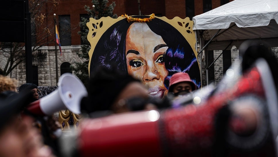 blurred megaphone in the bottom of the picture, image focused on painting of Breonna Taylor's face in the distance