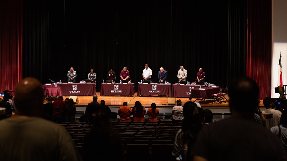 School board stand on stage in school board meeting