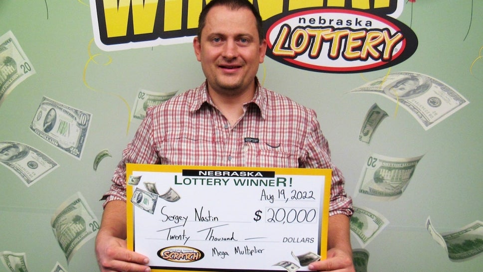 Sergey Nastin holding a large $20,000 check