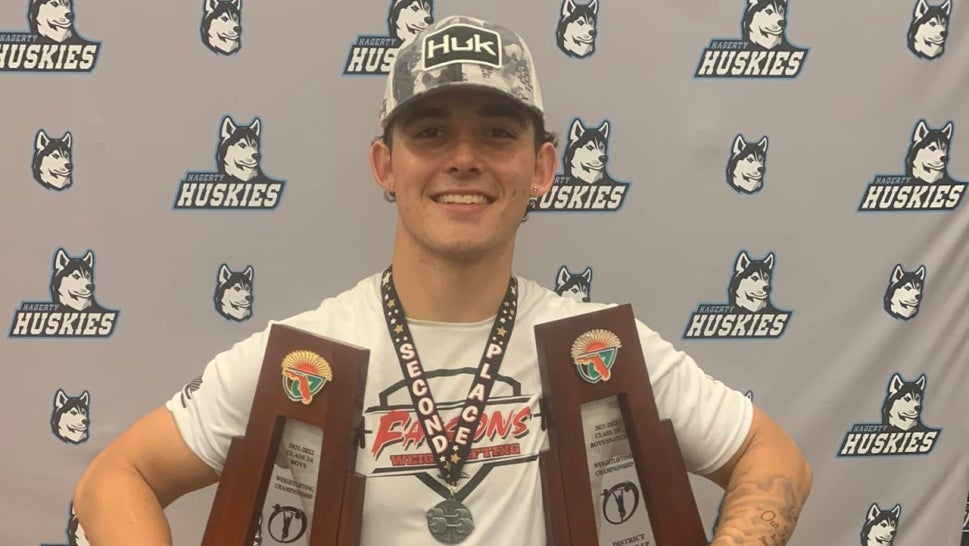 Miner smiling holding trophies