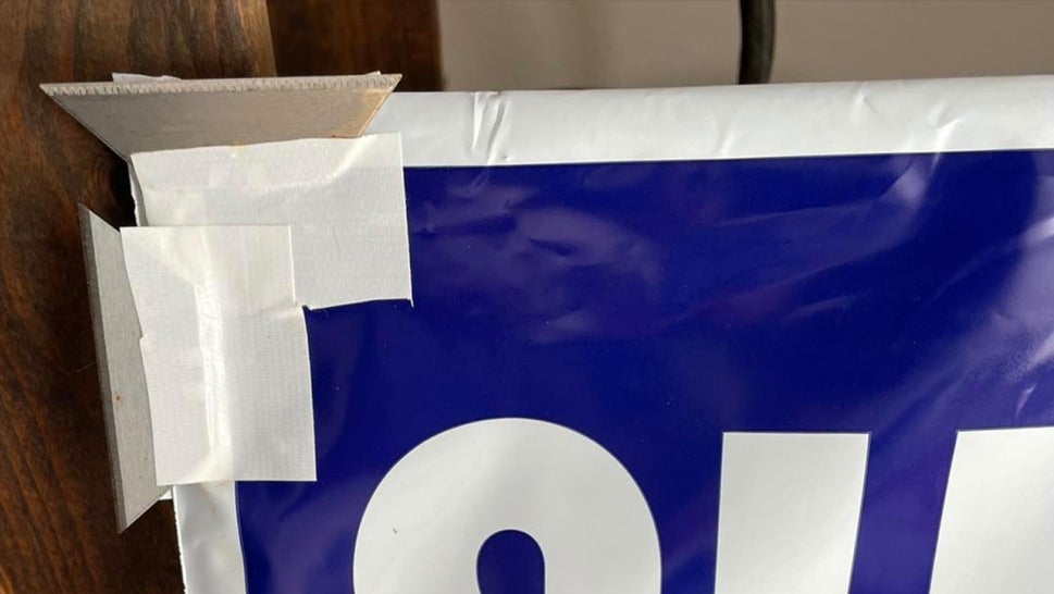 razor blades taped onto a corner of a campaign sign
