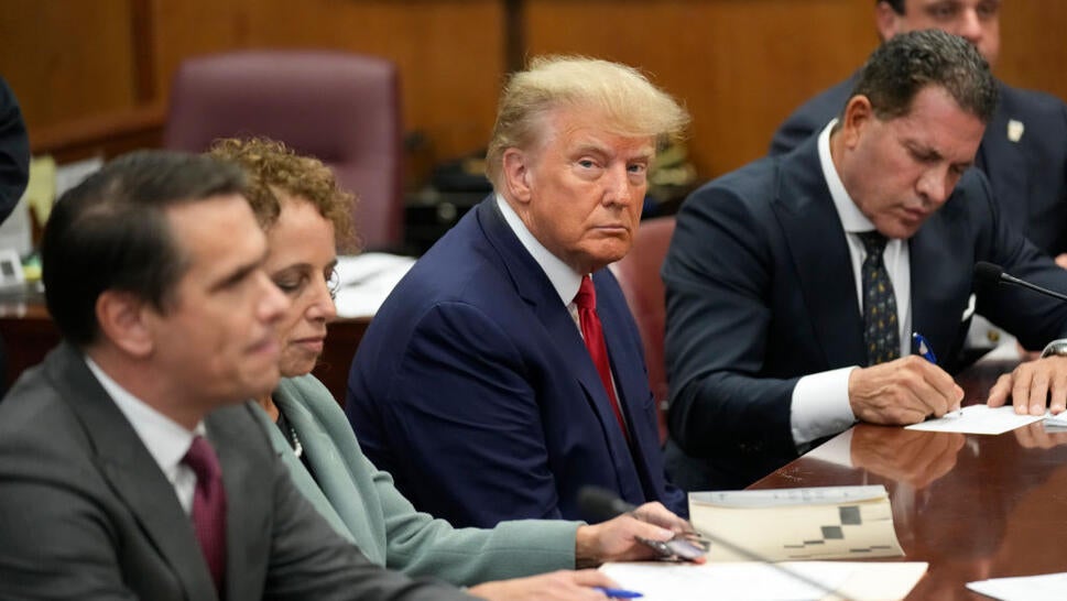 Former U.S. President Donald Trump sits at the defense table with his team in a Manhattan court during his arraignment on April 4, 2023, in New York City. (Photo by Seth Wenig-Pool/Getty Images)