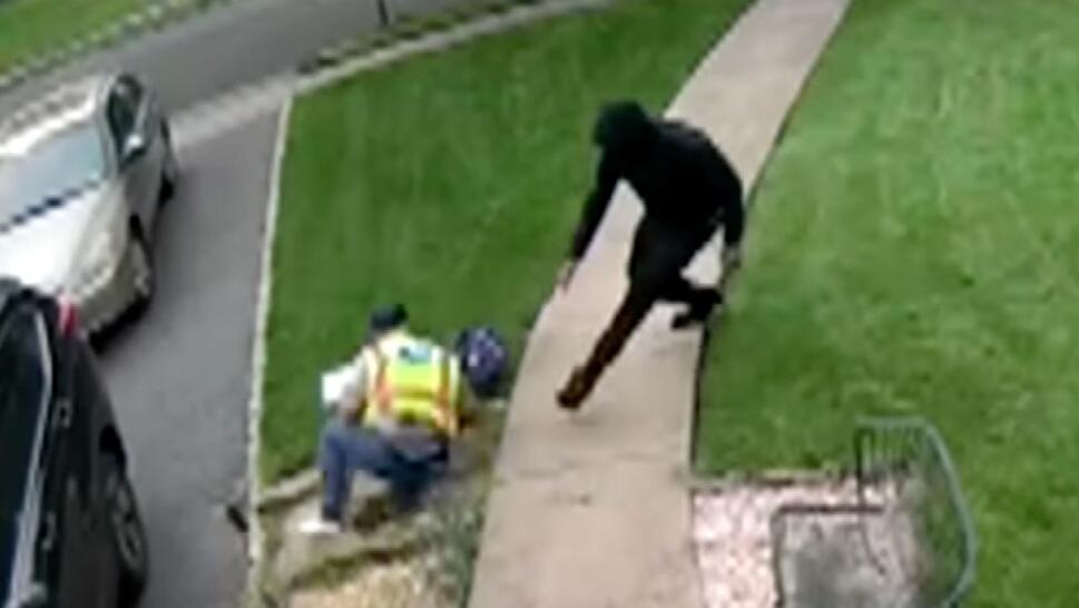 Postal worker on ground after thief dressed in all black pushes him