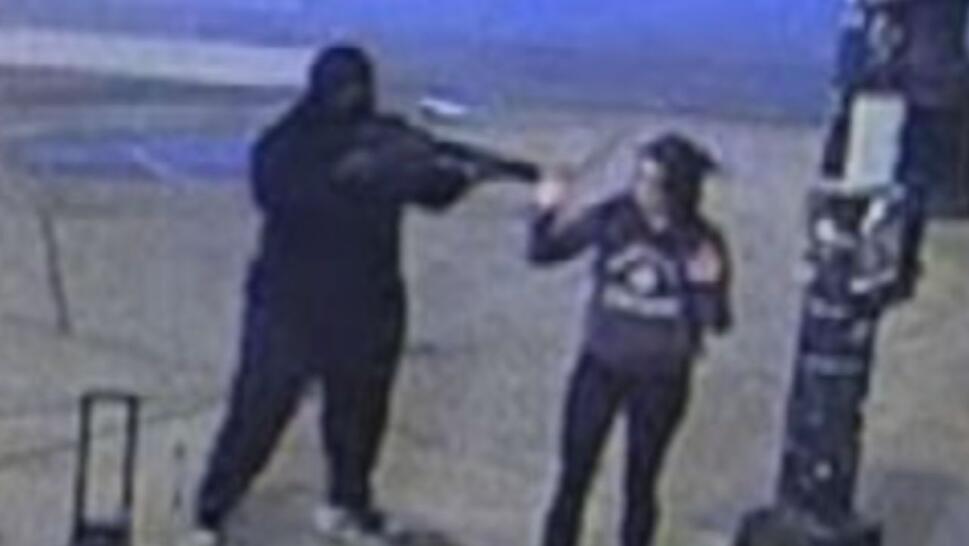man holding rifle against woman