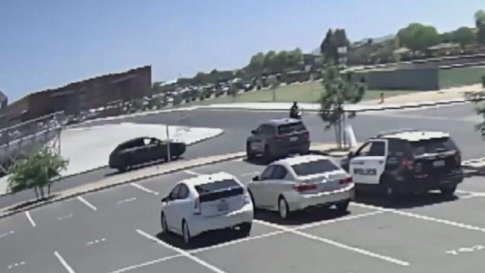 surveillance screengrab of school parking lot right before crash between car and motorcycle