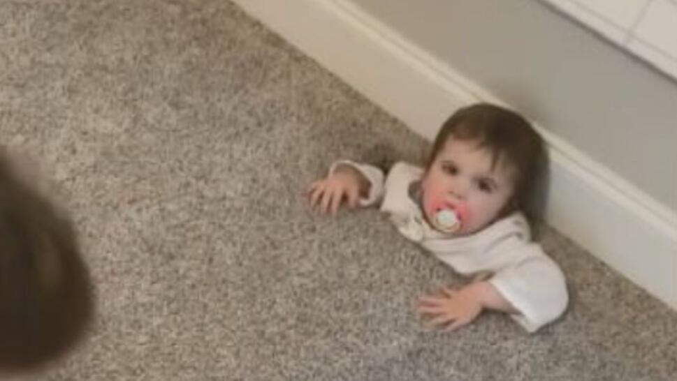 toddler with her lower body stuck in air vent