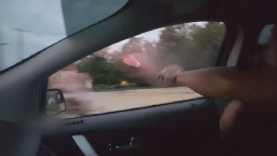 Police officer throwing drink outside of car window