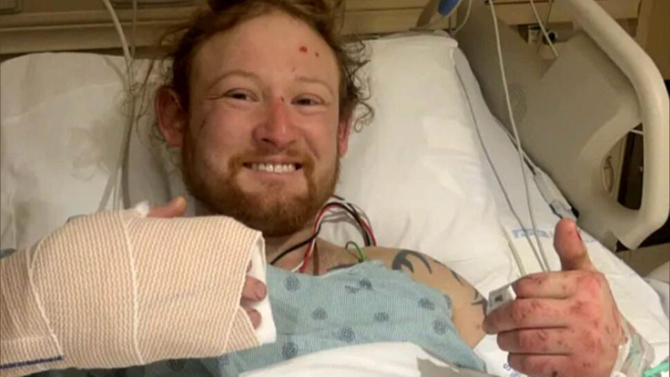 Matt Reum, who was trapped in a truck for six days, sitting in a hospital bed