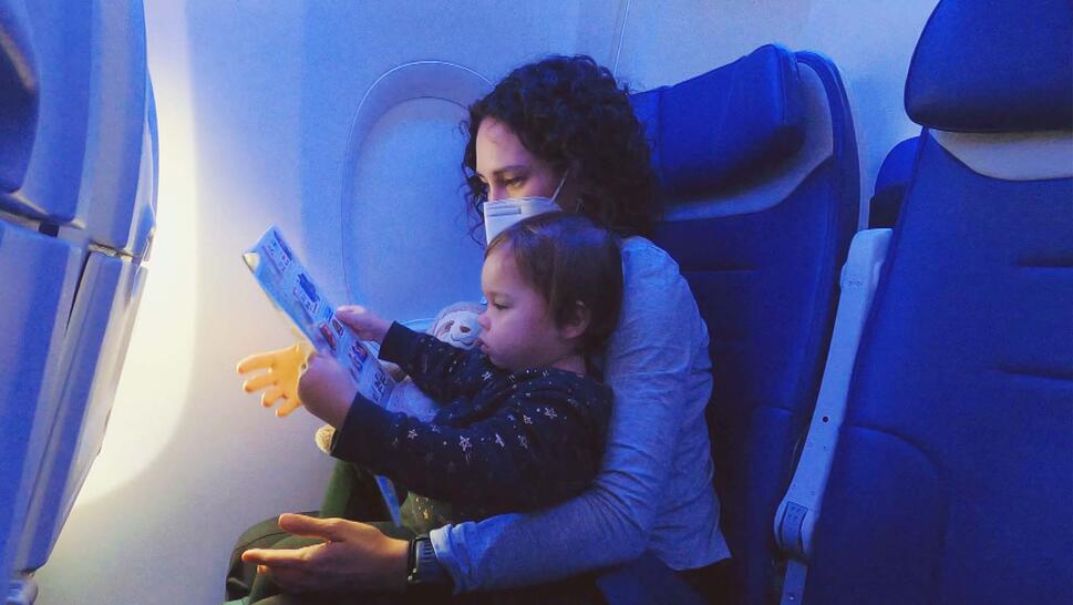 Woman holds baby on her lap in an airplane cabin