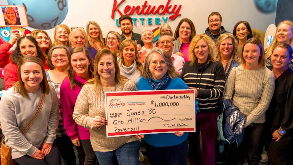 A group of teachers holding a large check for 1,000,000.00 dollars. 