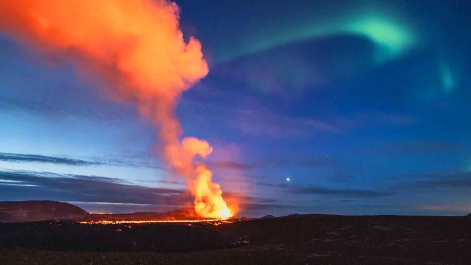 Aurora Borealis Dances Over Erupting Volcano in Iceland