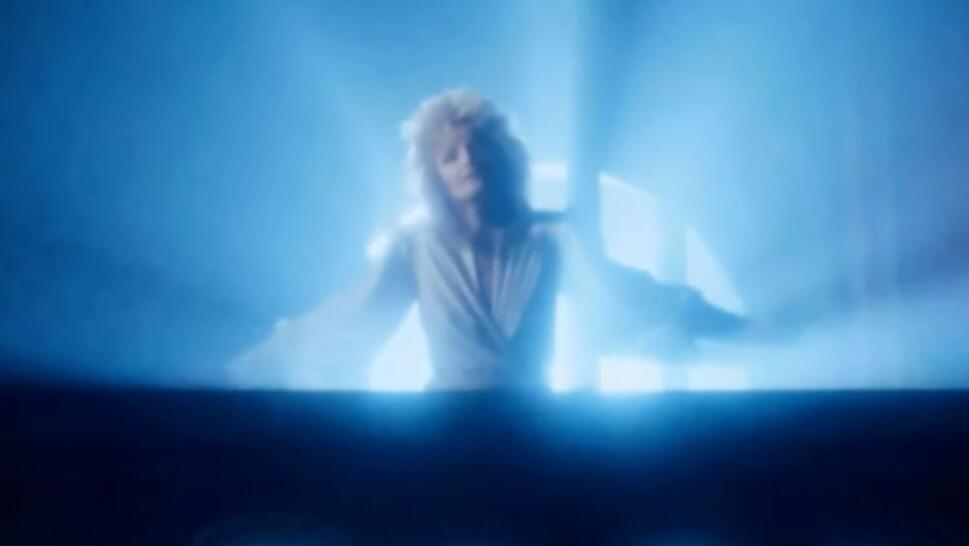 Bonnie Tyler standing in front of light in "Total Eclipse of the Heart" music video