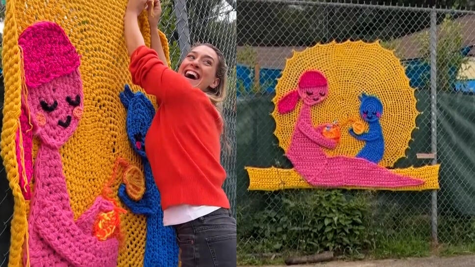 London Kaye hanging up a crocheted picture of a mother and child holding balls of yarn