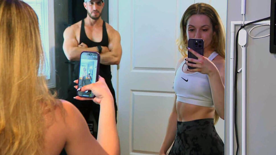 Woman taking a selfie in a gym wearing a sports bra.