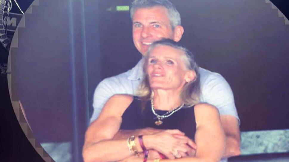 Man and woman embracing while standing watching a concert