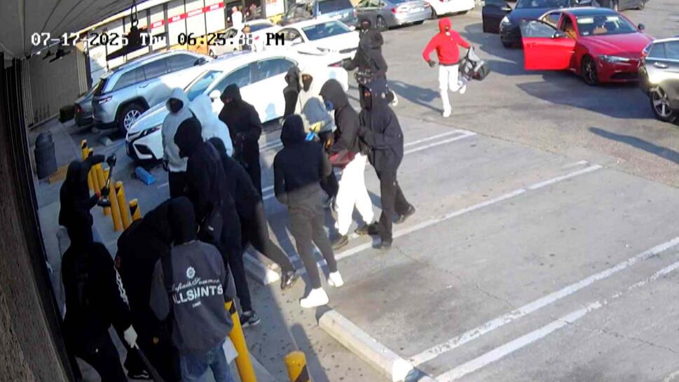 Large group of men crowding around the door to a jewelry store