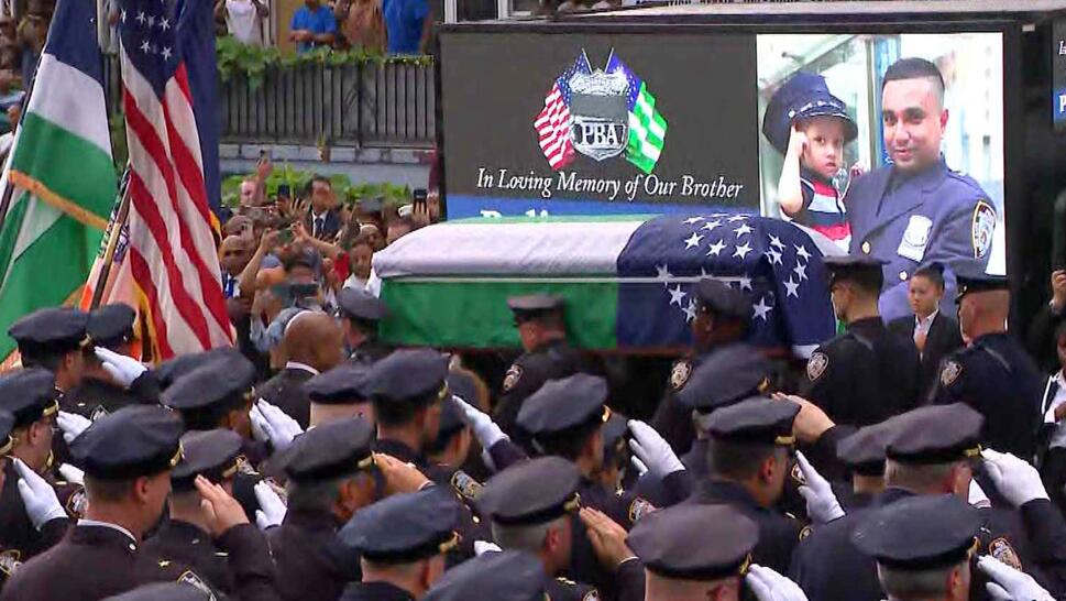 Police officers surrounding a coffin wrapped in a flag