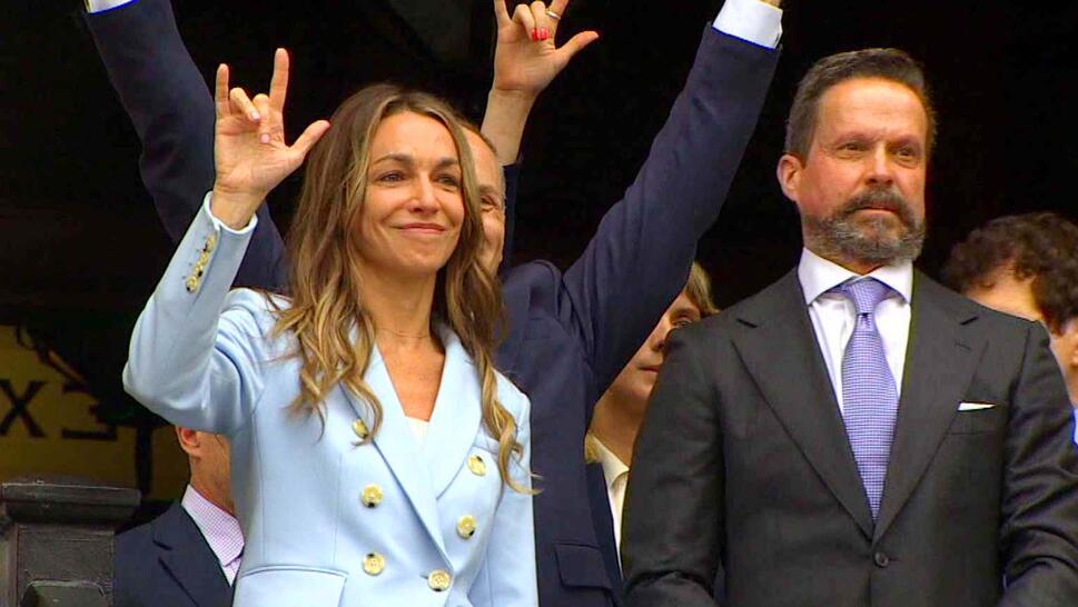 Karen Read holding up the ASL sign for 'I love you' from the court stairs after being aquitted