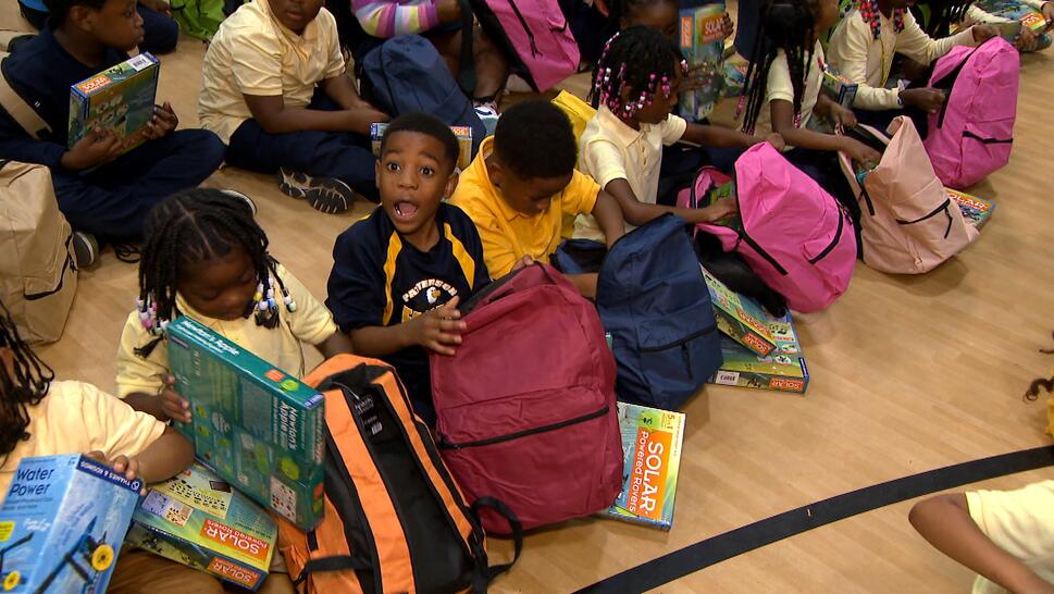 Children excited at getting new backpacks