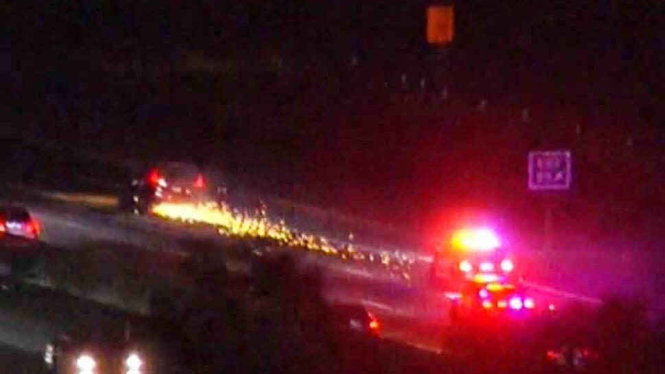 Cops chasing car with sparks flying from back.