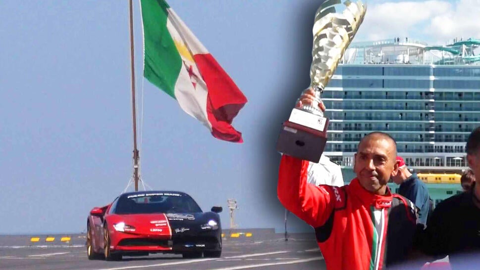 Ferrari in front of giant flag, man holding trophy high