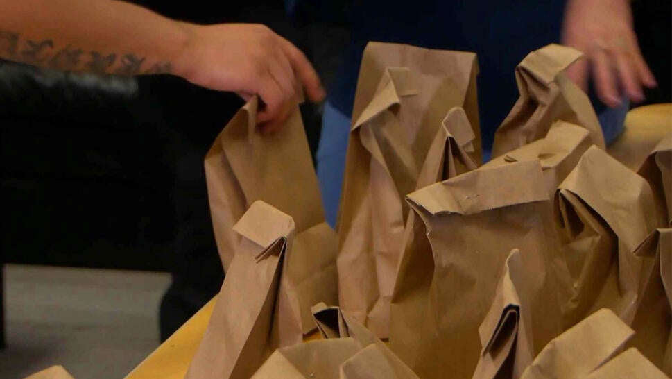 Hands grabbing brown paper bags