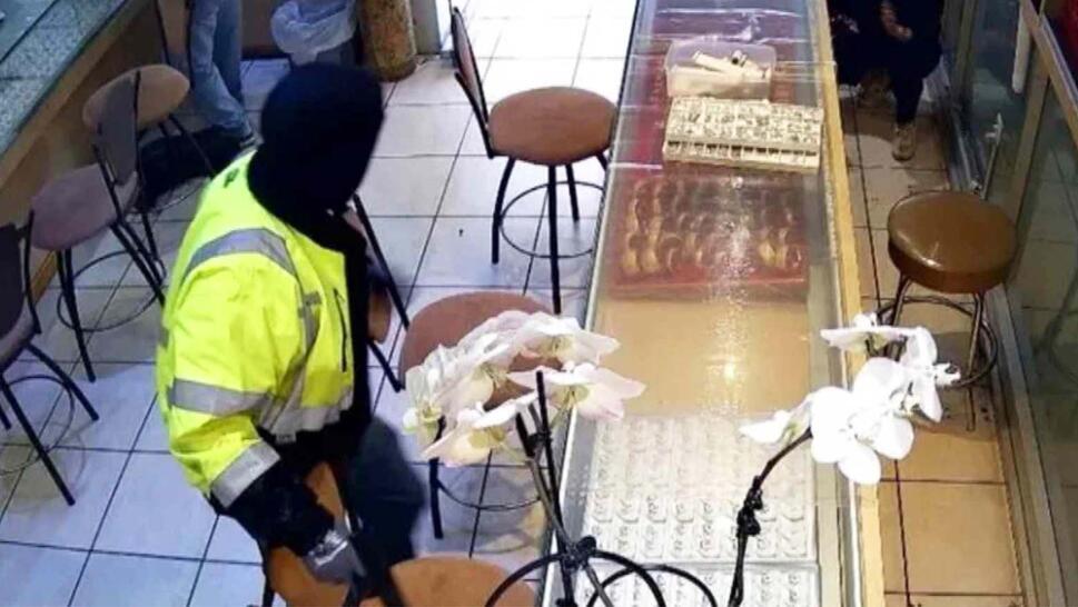 Man in construction reflective jacket standing over a jewelry counter