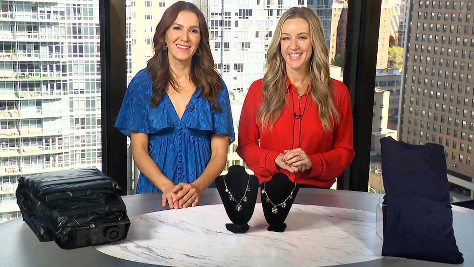 Two women standing behind a table displaying Air Mattress, Necklace, Thermal Set