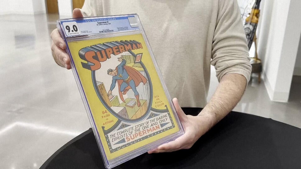 Rare Superman comic being held by seated figure