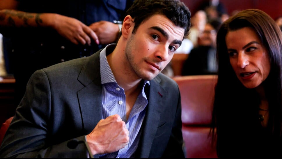 Luigi Mangione poses with clenched fist while conferring with woman in court