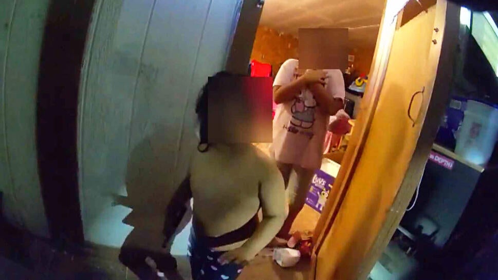 Children standing in the open door of a shed in the cold