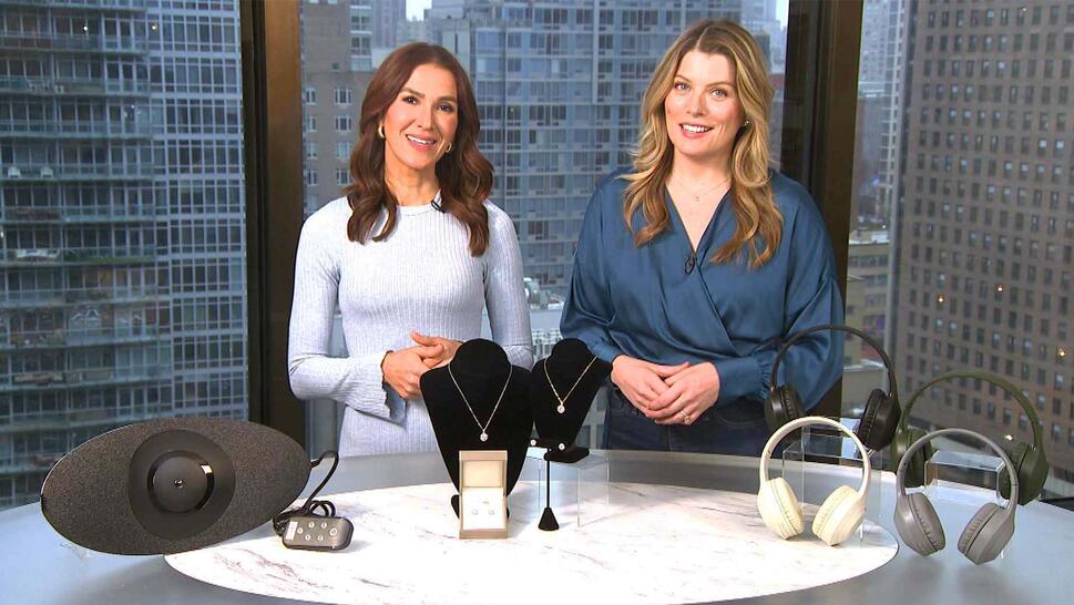 Two women standing behind a table displaying a Back Stretcher, Jewelry, Headphones