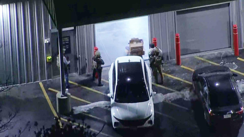 Drone view of officers standing outside of a storage unit