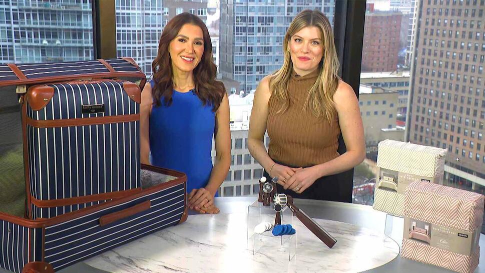 Two women standing in front of a table displaying a Luggage Set, Scrubber, Duvet Set
