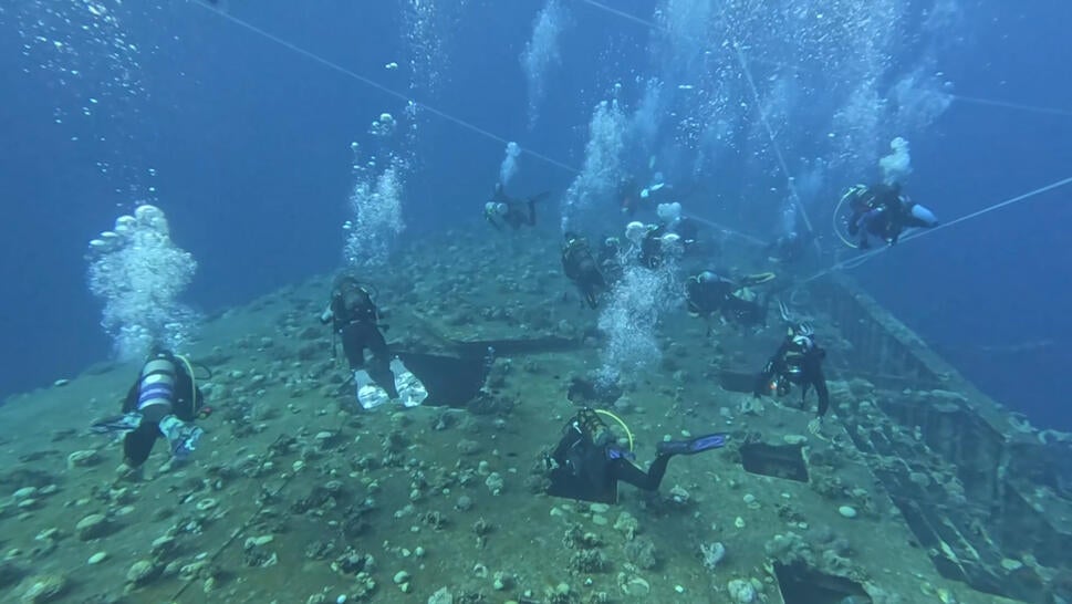 Divers exploring underwater wreckage