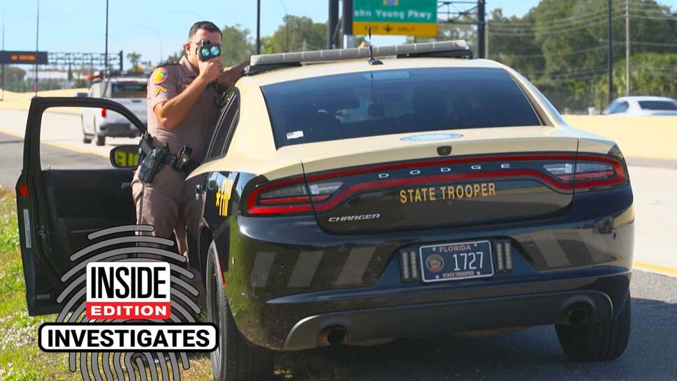 Florida State Trooper pointing a speed gun at cars passing on the highway